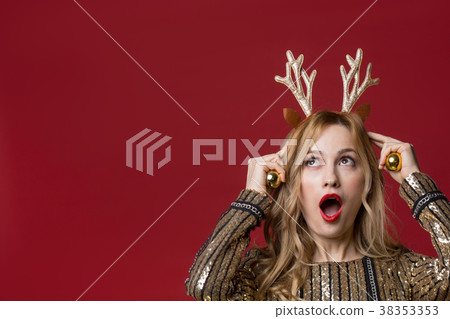 Amazed lady putting on holiday attribute on head 38353353