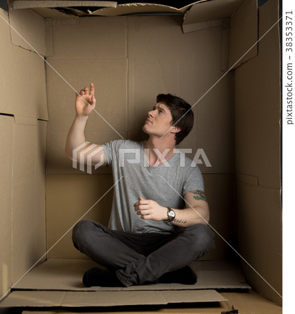 Guy is posing inside small carton room and 38353371