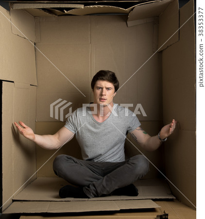 Irritated young man is gesticulating inside paper 38353377