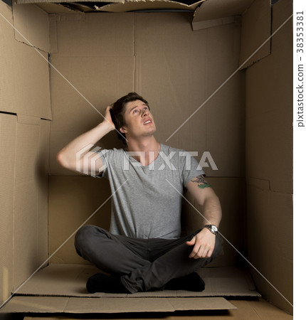Anxious guy is sitting in cardboard room 38353381
