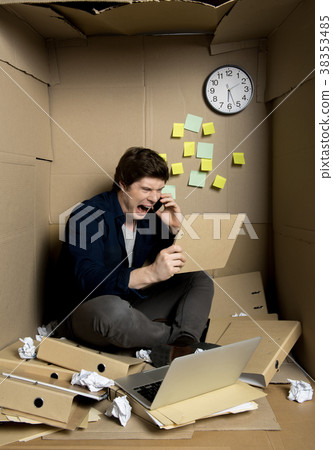Mad employee is yelling into smartphone 38353485