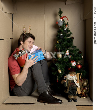 Guy is expressing happiness while holding presents 38354099