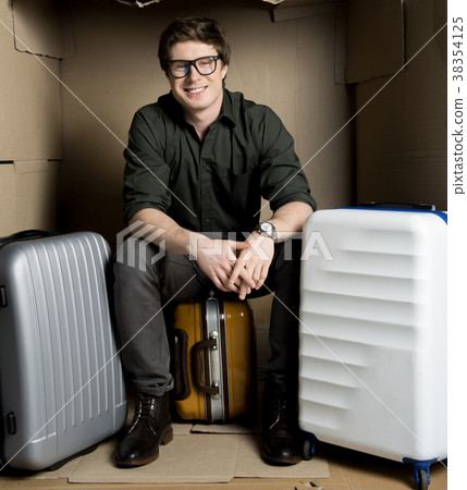 Positive guy is waiting for flight in cardboard 38354125