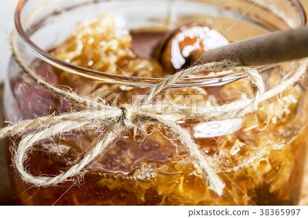 Fresh honey jar and dipper stick on a wooden board 38365997