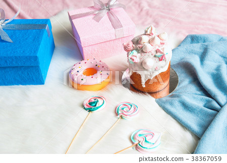 Presents with cake and sweets situating on floor Presents with cake and sweets situating on floor 38367059