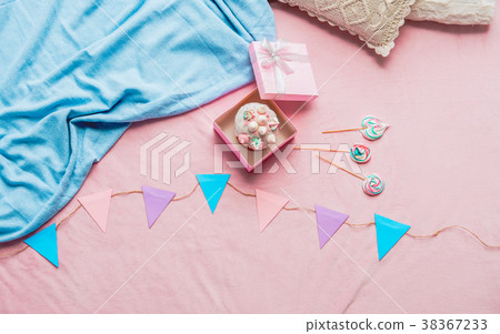 Cake in box near candies on carpet 38367233