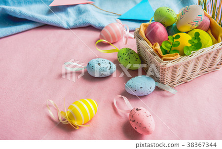 Small basket with easter colored eggs 38367344