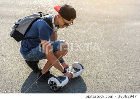 Outgoing young man walking with gyroscooter 38368947