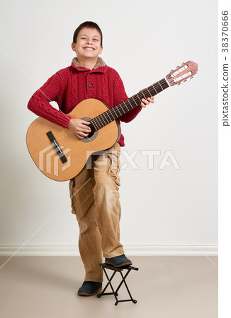 Boy is playing the acoustic guitar Boy is playing the acoustic guitar 38370666