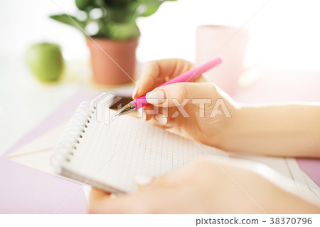 The female hands holding pen. The phone on trendy The female hands holding pen. The phone on trendy 38370796