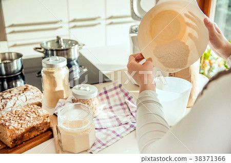 Woman in kitchen prepares dough for homemade bread 38371366