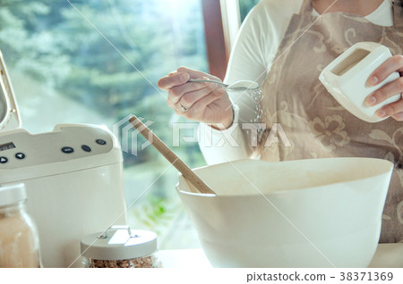 Woman pours salt into the dough 38371369