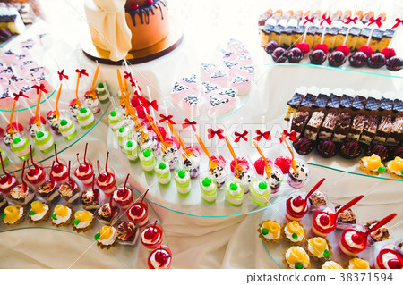 Delicious and tasty dessert table with cupcakes 38371594