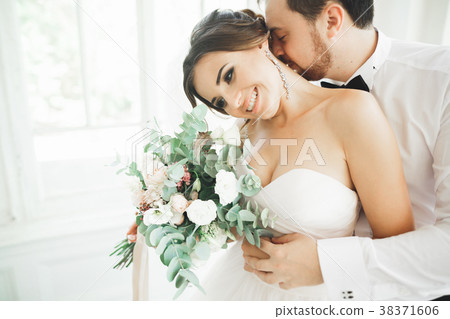Gorgeous groom gently hugging stylish bride Gorgeous groom gently hugging stylish bride 38371606