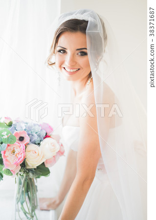 Luxury bride in white dress posing while preparing 38371687