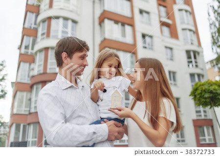 Happy family in front of new apartment building 38372733