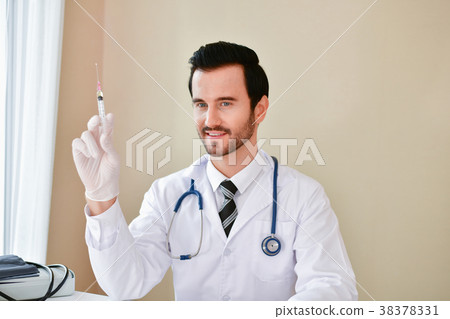 Smiling doctor posing in the office, he is wearing a stethoscope Smiling doctor posing in the office, he is wearing a stethoscope 38378331