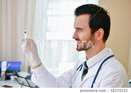 Smiling doctor posing in the office, he is wearing a stethoscope 38378332