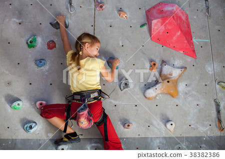 little girl climbing a rock wall indoor. little girl climbing a rock wall indoor. 38382386