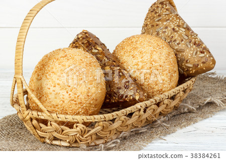 Bread buns in wooden basket on wooden background Bread buns in wooden basket on wooden background 38384261
