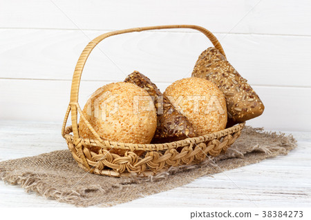 A fresh basket of golden brown hard crusted buns. 38384273