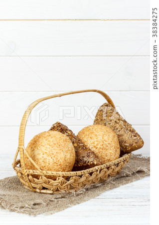 A fresh basket of golden brown hard crusted buns. 38384275