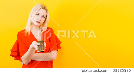 Blonde woman in dress with remote control 38385580