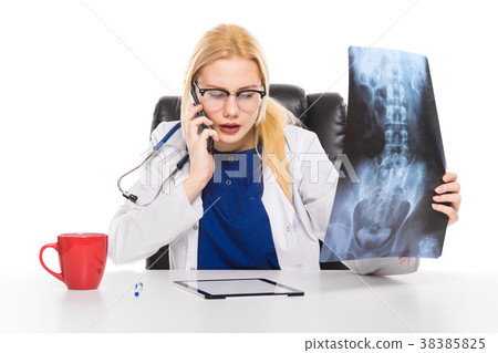 Woman doctor in white coat carefully studies X-ray Woman doctor in white coat carefully studies X-ray 38385825