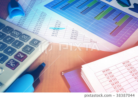 Calculator and financial figures on office table. 38387044