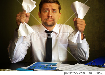 Nervous businessman observing bills.   38387052
