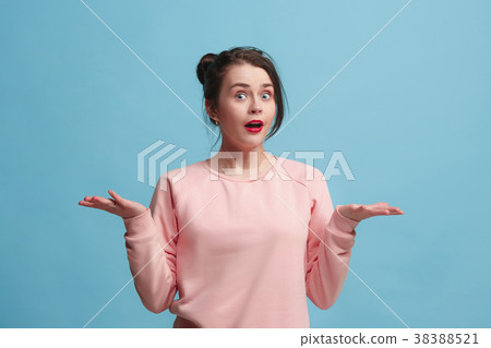 Portrait of dissatisfied young woman over blue 38388521