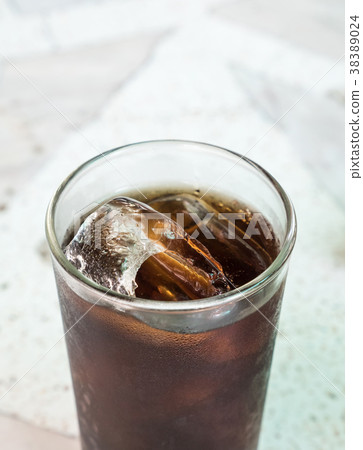 Cola with ice cube in the glass. 38389024