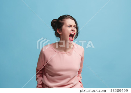 The young emotional angry woman screaming on blue The young emotional angry woman screaming on blue 38389499
