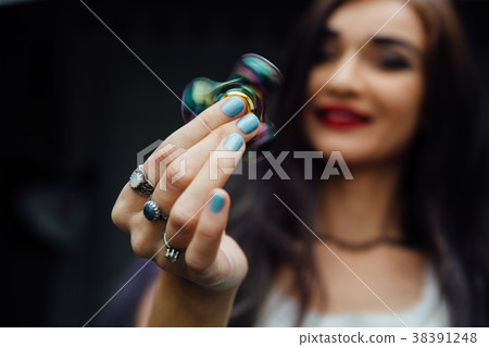 Girl's hand with fidget spinner. Holds a shiny Girl's hand with fidget spinner. Holds a shiny 38391248
