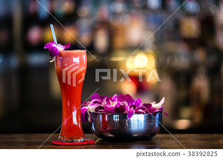 Red cocktail with orchid flower in the bar 38392825