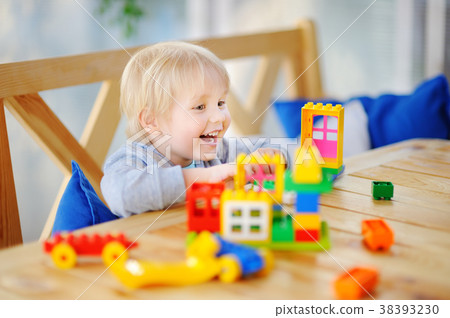 Little boy playing with colorful plastic blocks Little boy playing with colorful plastic blocks 38393230