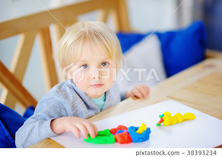 boy playing with colorful modeling clay boy playing with colorful modeling clay 38393234