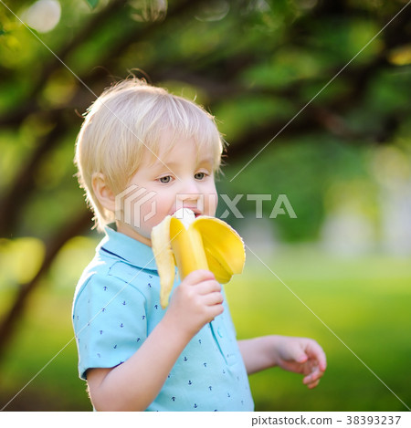 Beautiful little boy eating banana  38393237