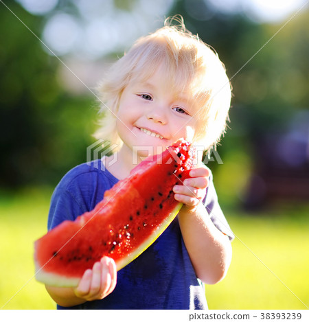 Cute little boy eating fresh watermelon outdoors Cute little boy eating fresh watermelon outdoors 38393239