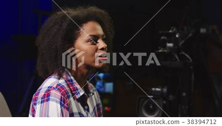 Casual black woman hosting TV show 38394712