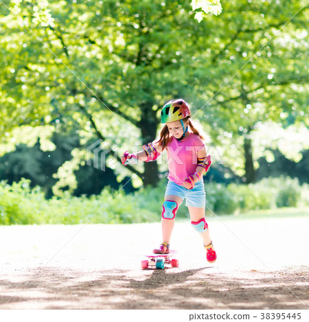 Child riding skateboard in summer park 38395445