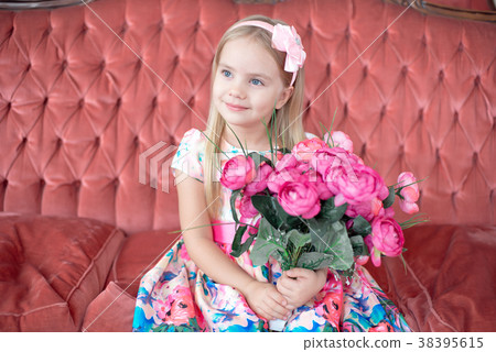 A little blond girl in colorful dress sitting on A little blond girl in colorful dress sitting on 38395615