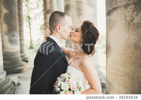 Portrait of happy wedding couple with head to head Portrait of happy wedding couple with head to head 38395638
