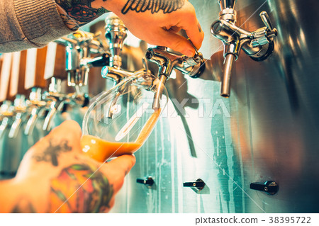 Hand of bartender pouring a large lager beer in Hand of bartender pouring a large lager beer in 38395722