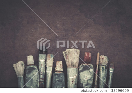 Paintbrushes, paint tubes closeup on dark canvas. Paintbrushes, paint tubes closeup on dark canvas. 38396699