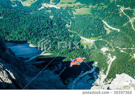 BASE jumper jumping off a big cliff in Dolomites 38397368
