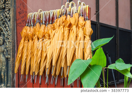 Stack of yellow umbrellas for sale at a stall Stack of yellow umbrellas for sale at a stall 38397773