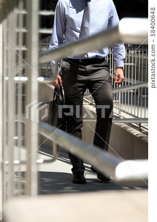 Businessman walking, holding a leather briefcase Businessman walking, holding a leather briefcase 38400648