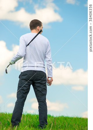 man with a golf club and balls examines the field 38406356