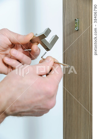 A man is installing a hook. 38406790